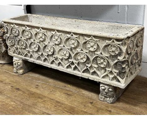 A composite stone garden planter in the Gothic style, of rectangular form decorated in relief with repeating rosettes, raised