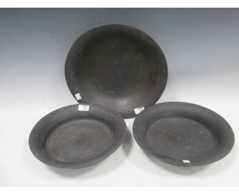 Three Wedgwood black basalt dishes largest 36cm diam and two others 30cm, impressed mark to the baseThe dishes have significa