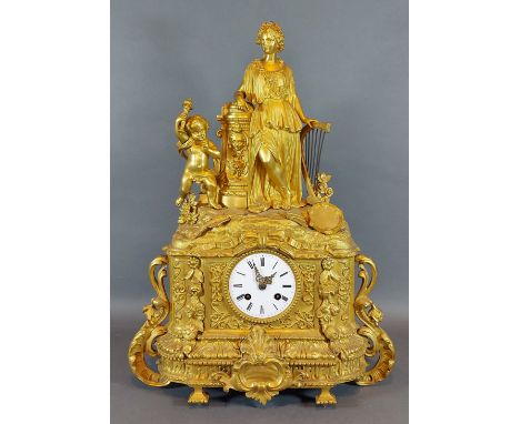 A 19th Century French ormolu mantle clock with figural surmount, the enamel dial with Roman numerals and with two train movem