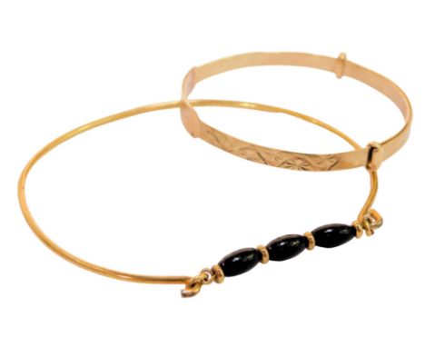 Two bangles, comprising a 9ct gold child's bangle, of expanding form, bearing the name Aiesha, 2.8g, and a further bangle set