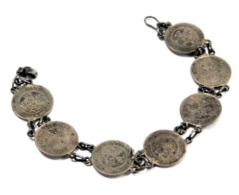A silver sixpence coin bracelet, set with seven silver coins, each with white metal chain links, 16cm long, 12g. 