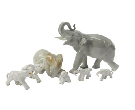 A USSR porcelain elephant, with trunk raised, 20cm high, an elephant calf seated, 9cm high, and further porcelain elephants. 