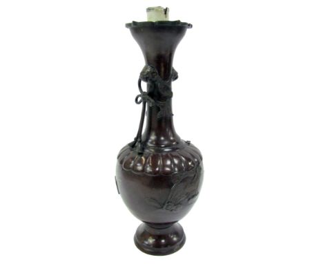 A Qing Dynasty late 19thC vase, of bottle form, with twin dog of fo head handles, with bow held in the mouth, one missing, de