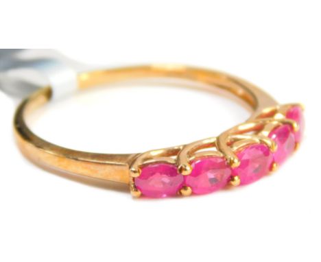 A ruby dress ring, set with five oval cut rubies, each in a claw setting, on a hooped over shank, yellow metal stamped 9kt, r
