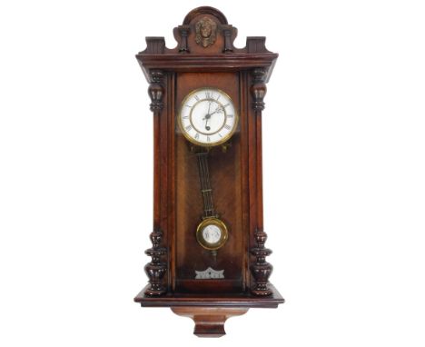 An early 20thC walnut cased Vienna wall clock, circular white enamel dial bearing Roman numerals, thirty hour, 78cm high.
