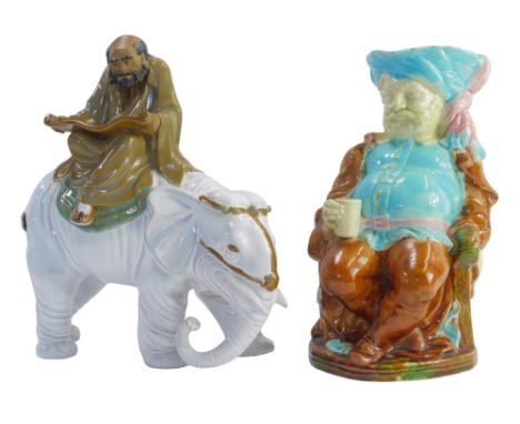 A Chinese Wang Tang pottery figure depicting an man reading a scroll on an elephant, 27cm high, together with a Majolica pott