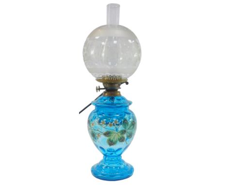 A Victorian oil lamp, with frosted and clear glass globular shade decorated with flowers, with a blue glass base decorated wi