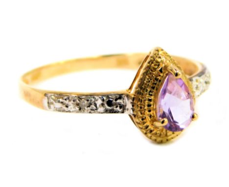 A lady's dress ring, claw set with a central amethyst coloured stone, flanked by small diamonds to each shoulder, marked 375,