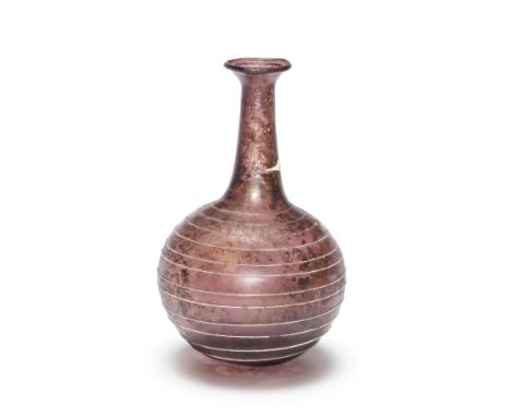  A Roman aubergine glass bottle with opaque white trail Circa 1st Century A.D.11.3cm high Footnotes:Provenance:Collection Mon