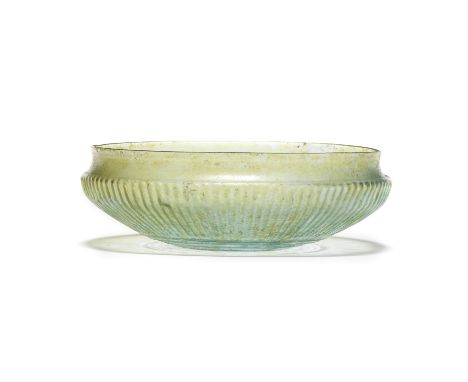  A Roman pale blue green glass finely ribbed shallow bowl Circa early 1st Century A.D.13.4cm diam.Footnotes:Provenance:Dr. K.