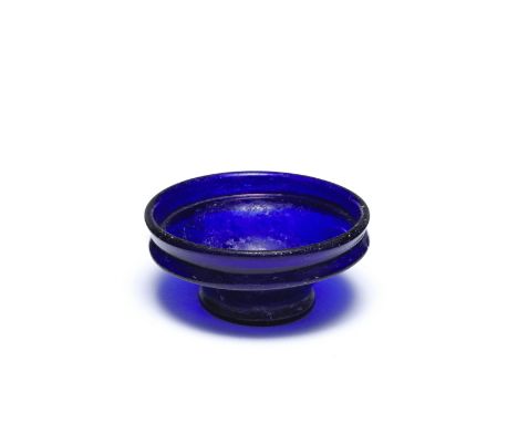  A miniature Roman cobalt blue glass collared bowl Circa 1st Century A.D.5.3cm diam. Footnotes:Provenance:Anonymous sale; Mil