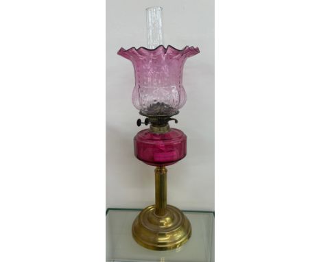 Antique brass collum base cranberry glass oil lamp complete with shade and funnel. 