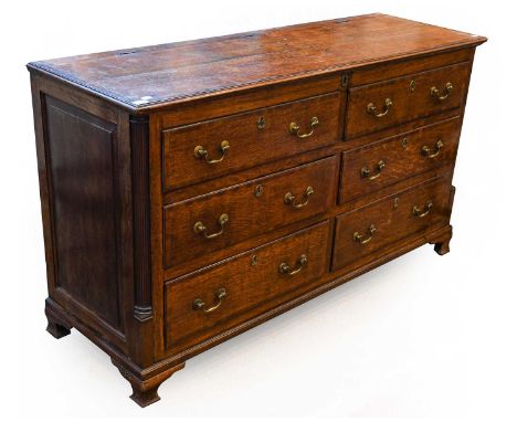 A George III Oak and Mahogany Crossbanded Lancashire Mule Chest, circa 1800, the moulded hinged lid above two sham and four r