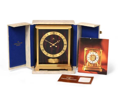 A Brass Atmos Clock, signed Jaeger LeCoultre, model: Embassy VII Red, circa 1970, faux marble red side panels, base with star