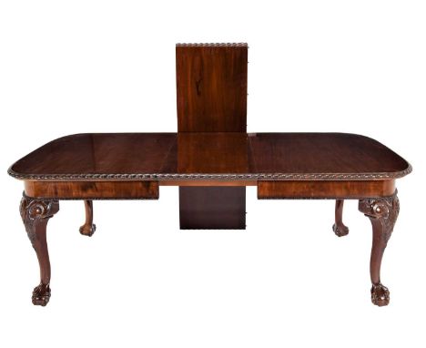 A Victorian Mahogany Wind-Out Dining Table, late 19th century, with two original leaves and a carved border, on bold acanthus