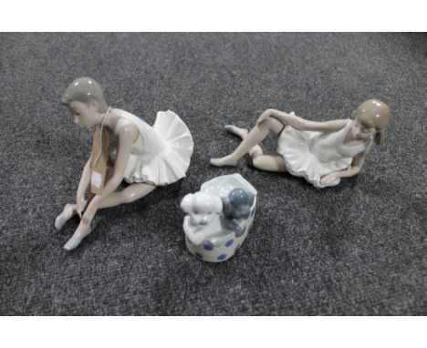 Two Nao figures of ballerinas together with another Nao figure of two puppies in a basket 