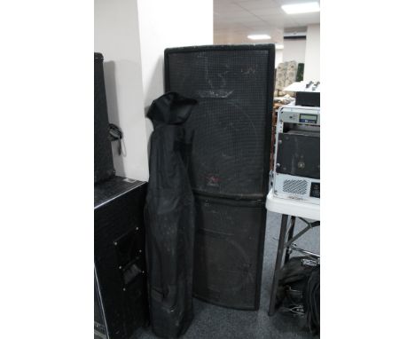 A pair of Peavey XT Series PA speakers and a bag of PA speaker stands. 