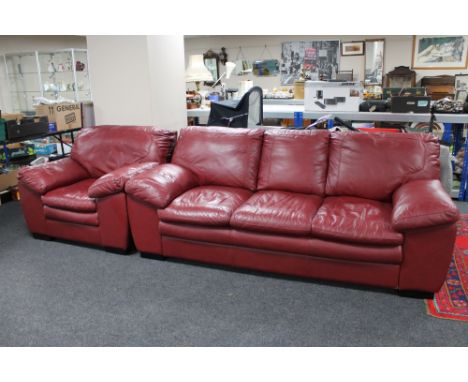 A red leather three seater settee and armchair. 