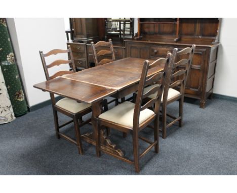 An Ercol refectory dining table and four ladder back chairs. 