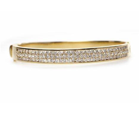 EIGHTEEN CARAT GOLD DIAMOND SET BANGLEof oval form, hinged, with a rectangular grain set diamond panel, 62mm across, 33.5g