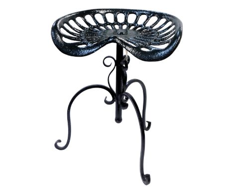A green painted cast iron tractor seat, on a black painted wrought iron base, 58cm high. 