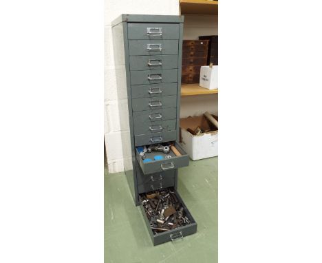Fifteen drawer metal chest enclosing a quantity of clock and watch tools and spares