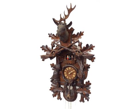 20th century Black Forest cuckoo clock, the 4" dial under a balcony with four revolving figures, the case carved with hanging