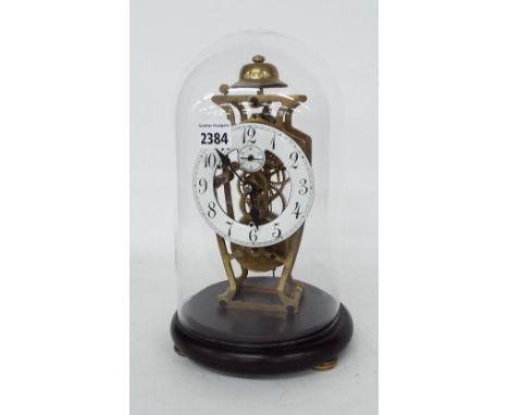 Brass skeleton timepiece, the 4.25" white chapter ring enclosing a skeletonised centre with subsidiary seconds dial, under a 