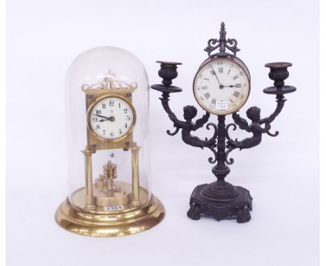 Candelabra drumhead clock timepiece, the 3.5" dial within a brass drumhead surround upon a spelter twin light pedestal modell