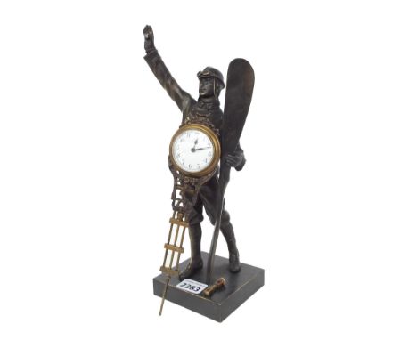 Bronzed mystery clock modelled as a standing pilot holding a propeller in one hand and the swinging movement aloft in the oth