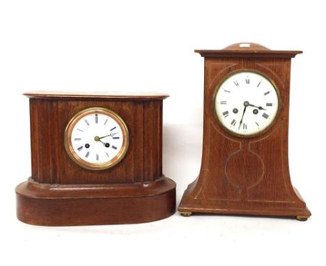 French oak two train mantel timepiece striking on a bell, the 3.5" white dial within a rounded shaped fluted stepped case, 9.