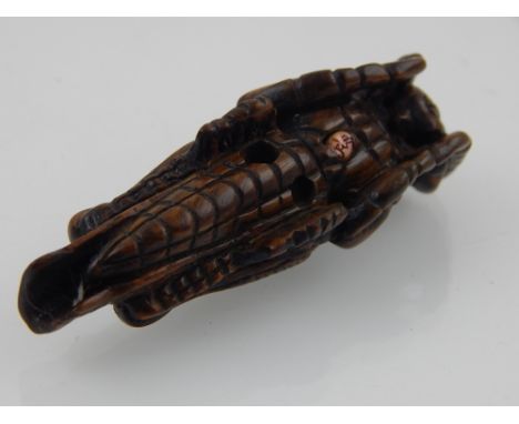 A Japanese Meiji carved boxwood netsuke modelled as a grasshopper L 7 cms bears character mark