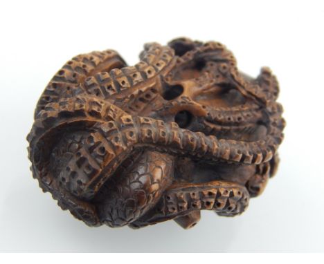 A Japanese Meiji carved boxwood netsuke modelled as a coiled octopus W 4 cms bears character mark