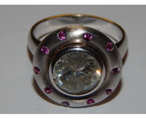 A diamond and pink sapphire dress ring, the collet set central stone of approx. 3ct, within a band of pink sapphires, on a 14