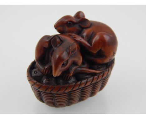 A Japanese carved boxwood netsuke modelled as two mice on an oval wicker basket  W 4.5 cms 