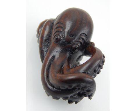 A Japanese Meiji carved boxwood netsuke modelled as a coiled octopus L 7 cms, beards character mark.