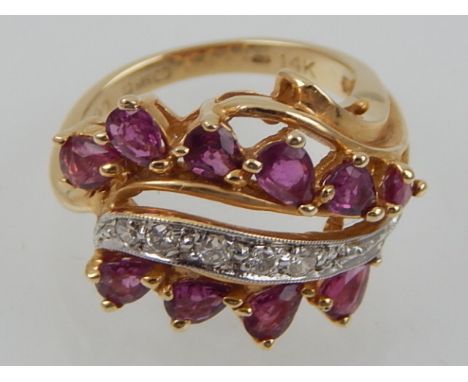 A 15ct yellow gold, diamond and ruby dress ring, of open triple strand form, claw set with circular and faceted pear shaped s