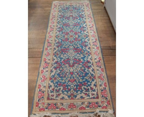 A Kashan runner, the foliate decoration on a light blue ground, 244 x 72cm