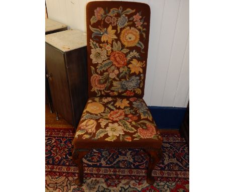 A pair of Queen Anne style walnut high back dining chairs, with polychrome floral tapestry upholstery, on carved cabriole leg
