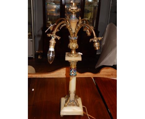 An early 20th century French gilt metal, champleve enamelled onyx four branch table lamp, with dolphin cast Corinthian column