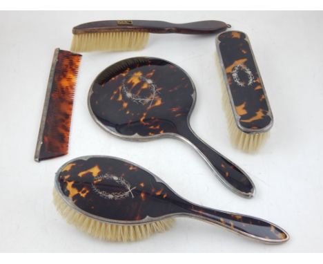 A silver and tortoiseshell dressing table set, London 1936, comprising hand mirror, two brushes and a comb, together with ano