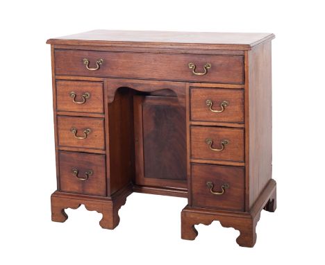 A mahogany kneehole desk in George II style, 19th century; the top with moulded edges, above a long drawer and six short draw