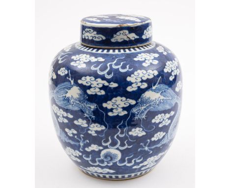 A Chinese porcelain jar and cover, painted in blue with an opposing pair of dragons competing for a flaming pearl, amongst cl
