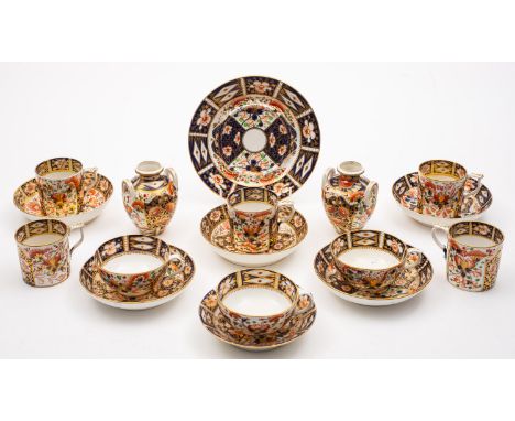 A group of Derby porcelain tea wares, decorated in the Imari pattern comprising three cups, five cans, six saucers, a stand a