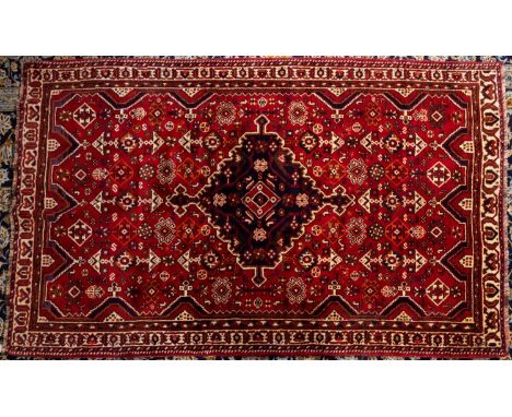 A Qashgai carpet, the wine field with a central indigo shaped lozenge pole medallion, all over geometric designs and main ivo