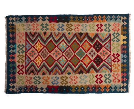 A Turkish Kelim, the stepped lozenge field in red, beige and various colours, enclosed by a main beige geometric medallion bo