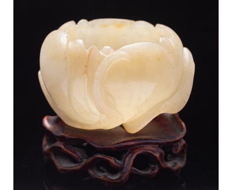 A Chinese carved jade Lotus waterpot in the form of an open lotus flower with an overlapping leaf and stalks, the stone of gr
