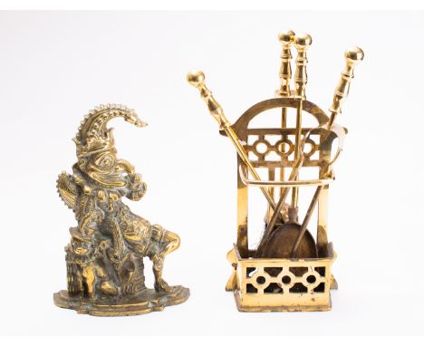A brass doorstop cast as Mr Punch, early 20th century; portrayed as seated, with shaped base, 30cm high; and a brass hearth s
