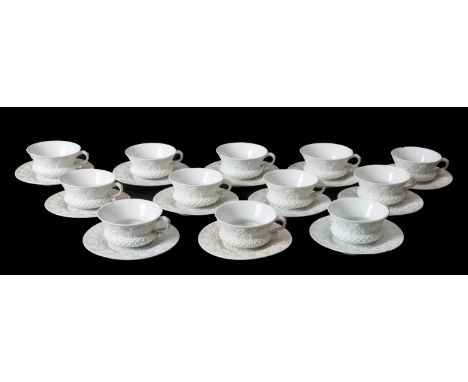 Twelve Meissen porcelain thistle shaped cups and saucers both embossed with a series of arches, in the white, blue crossed sw