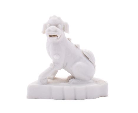 A small Chinese blanc-de-chine figure of a Buddhist lion, Qing dynasty early 18th century, on shaped oval base, 7.5cm high [p